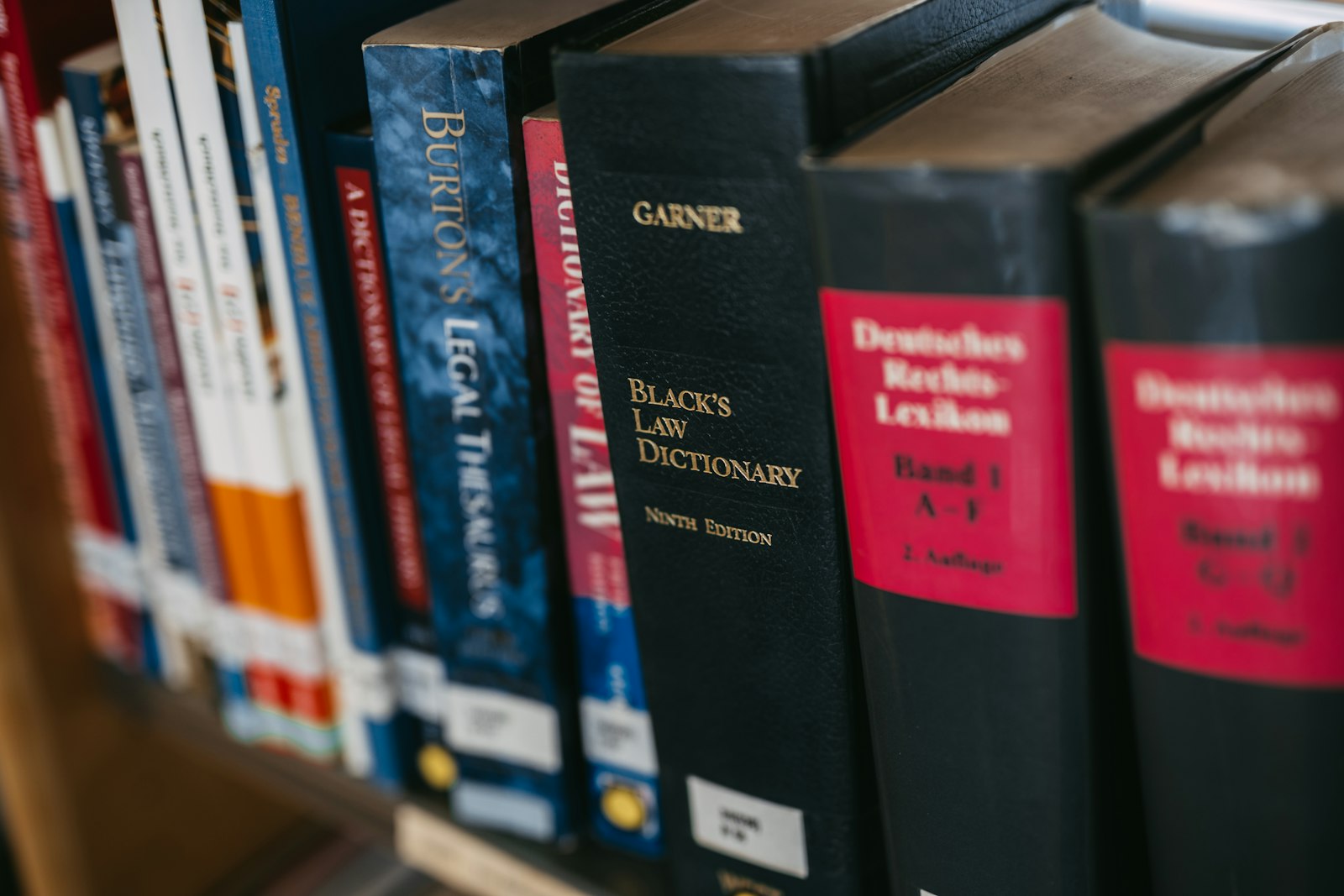 Reference legal texts and law dictionaries lined up on a shelf